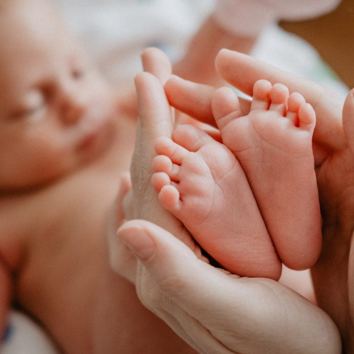 Newborn feet in mother hands. Happy Family concept.
